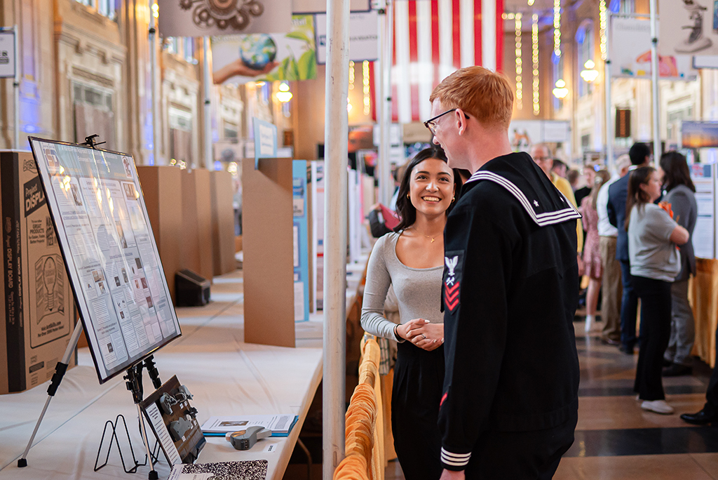 Photo showing a contestant at the science fair explaining her project to a judge.