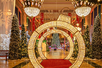 Image from Holiday Reflections showing a light up walk through ornament and light up crowns hanging from the ceiling.