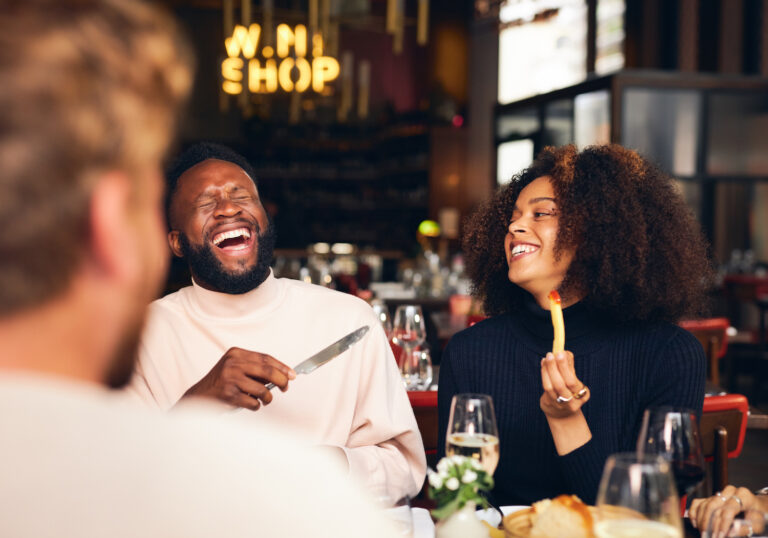 Couple eating meal and laughing in a restaurant