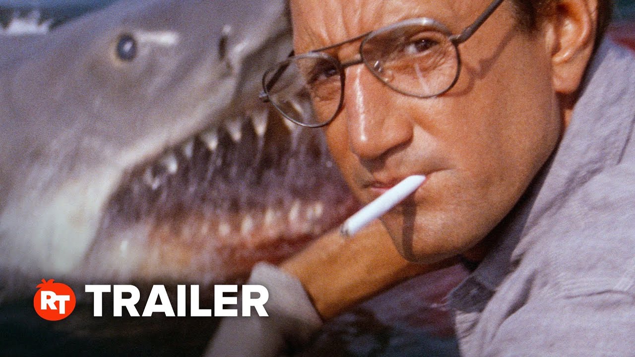 Image for the trailer of the film Jaws. Showing a man with a shark in the background.
