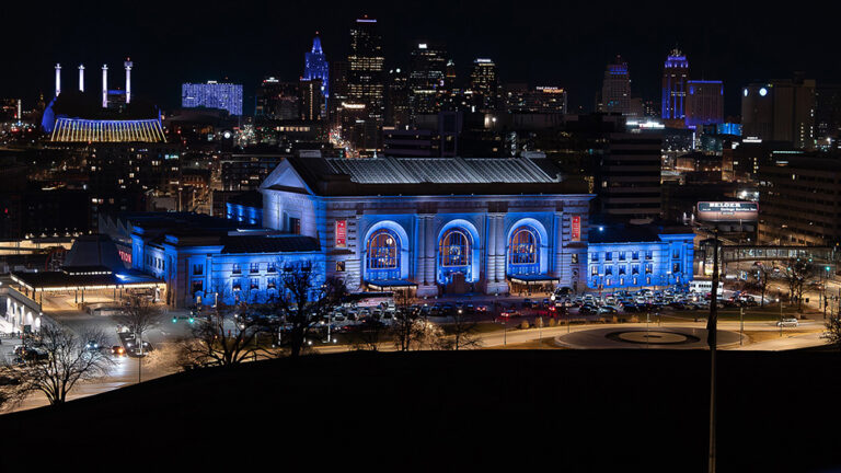 Union Station Kansas City with blue lights and the downtown skyline in the background.