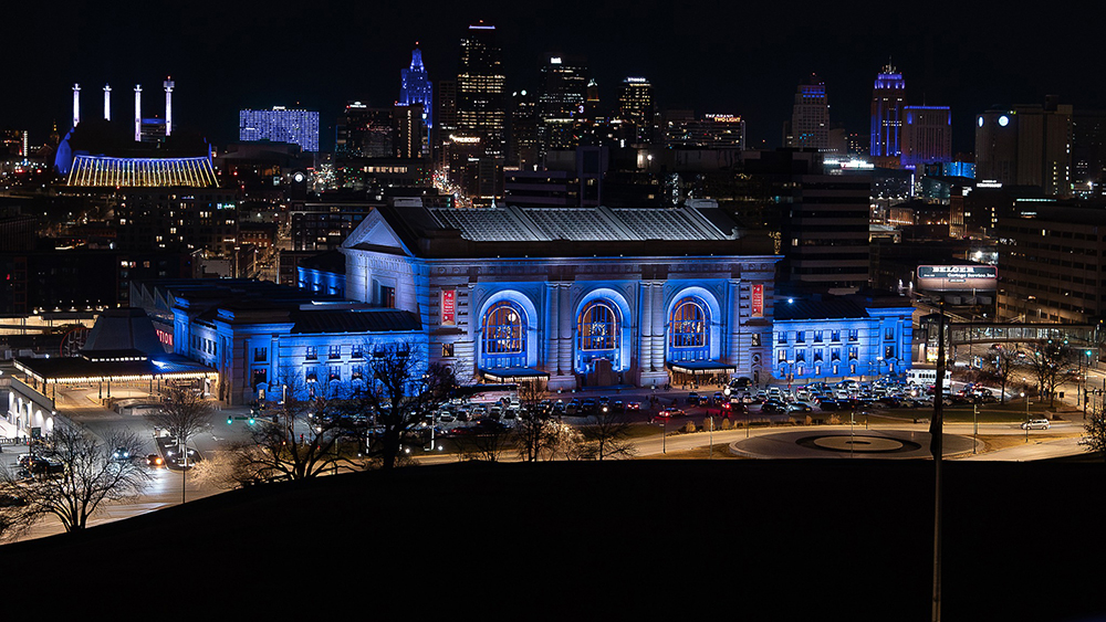Union Station Kansas City with blue lights and the downtown skyline in the background.